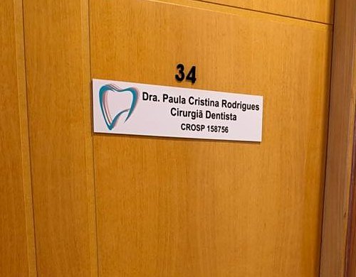 Placa na porta de madeira da sala 34: Dra. Paula Cristina Rodrigues, cirurgiã-dentista, CROSP 158756